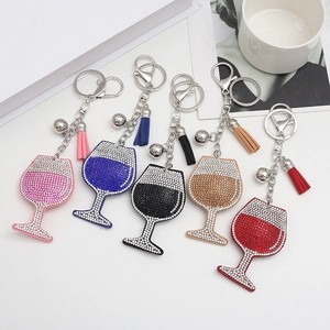 Vue détaillée de cinq porte-clés en forme de verre à vin avec pompons en cuir colorés
