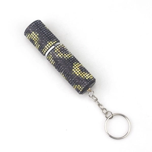 Detail view of lipstick-shaped keychain with black and yellow rhinestone crystal inlay