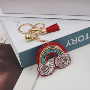 Portachiavi arcobaleno con strass e nappa rossa su libri per borse e auto
