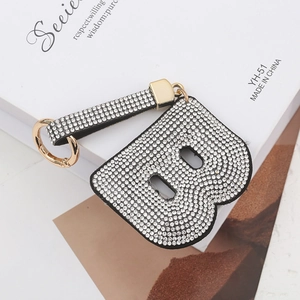 Détail macro du porte-clés luxe lettre B orné de strass et d'un anneau doré élégant