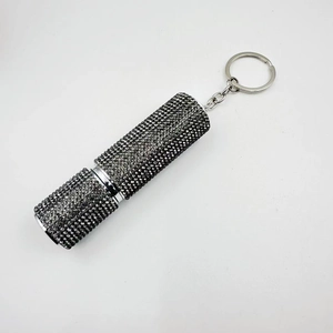 Macro shot of the mini 10ml perfume bottle with gun-black rhinestones and a metal keychain