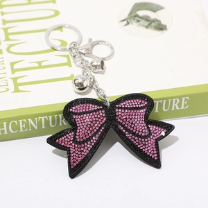Dettaglio del portachiavi a fiocco con strass rosa con chiusura a moschettone e campanellino