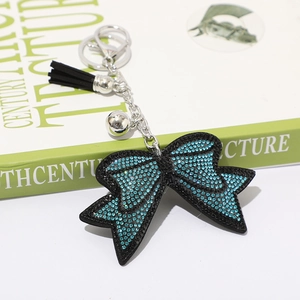 Portachiavi con fiocco di strass, nappe nere e campanellino su catena di metallo argento