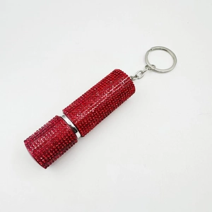 Lipstick-shaped keychain with red rhinestones and silver metal ring on white background