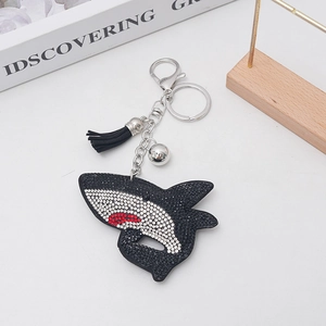 Detail of shark rhinestone keychain with silver metal clip and black leather tassel