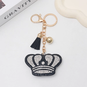 Dettaglio del portachiavi a corona con strass, nappa nera e accessori dorati