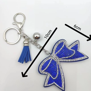 Dettaglio portachiavi fiocco con strass blu e nappa in pelle, dimensioni di 10cm per 6cm