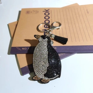 Detailed view of penguin keychain featuring black and white rhinestones and a black tassel