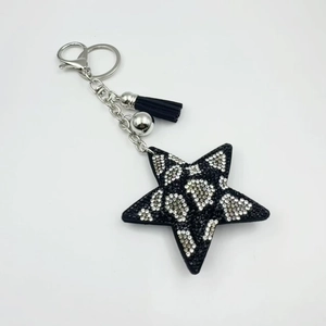 Detailed macro of leopard print star keychain with rhinestones, black tassel and silver clasp