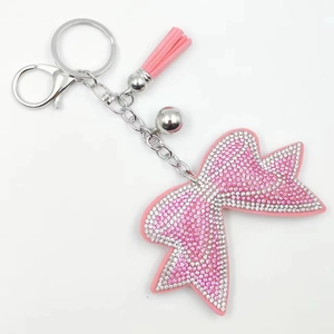 Dettaglio portachiavi con fiocco di strass rosa, nappa in pelle e chiusura argento