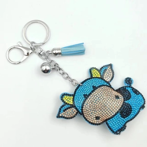 Porte-clés bœuf en strass bleus avec clochette argentée et pompon en cuir élégant