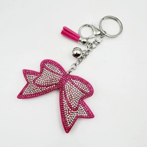 Dettaglio del portachiavi a fiocco con strass rosa, nappa in camoscio e campanellino