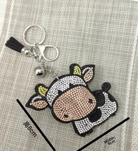 Détail du porte-clés vache en strass avec pompon en cuir et dimensions de 8cm sur 9cm