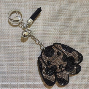 Détail du porte-clés chien en cristal avec strass bicolores et pompon noir élégant