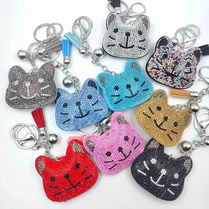 Close-up of cat head keychains with colorful rhinestones and matching tassels on white background