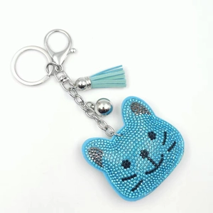 Close-up of blue rhinestone cat keychain with silver bell and light blue leather tassel