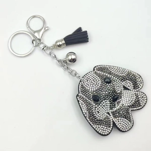 Porte-clés tête de chien en cristal avec strass blancs et un pompon en cuir noir élégant