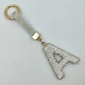 Detailed macro view of gold-tone letter A keychain with white rhinestones and a spring ring