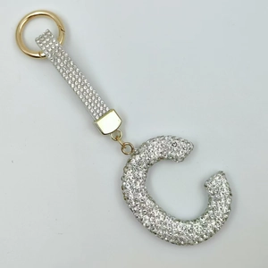 Detailed macro view of letter C keychain featuring sparkling silver rhinestones and gold ring