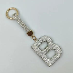 Detailed close-up of sparkling white rhinestone encrusted letter B keychain in gold finish