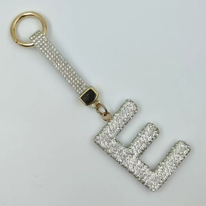Detailed close-up of a sparkling rhinestone letter E keychain with a white strap