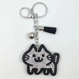Close-up of sparkling rhinestone husky keychain with black leather tassel and silver bell