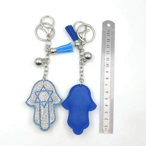 Detailed view of Hamsa Hand keychains with blue star rhinestones, tassels and steel ruler
