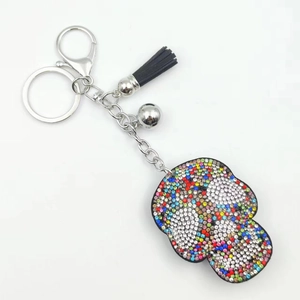 Detail of colorful rhinestone keychain with silver hardware and black leather tassel