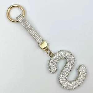 Detailed close-up of a golden capital letter S keychain with sparkling crystal rhinestones