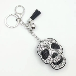 Detail view of rhinestone skull keychain with black leather tassel and silver metal hook