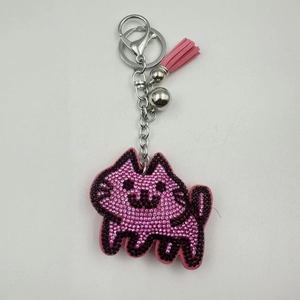 Close-up of pink rhinestone cat keychain with faux leather tassel and silver bell
