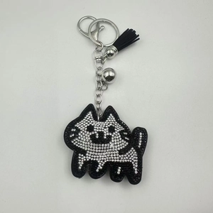 Detail of rhinestone cat keychain with black tassel, silver bell and lobster clasp