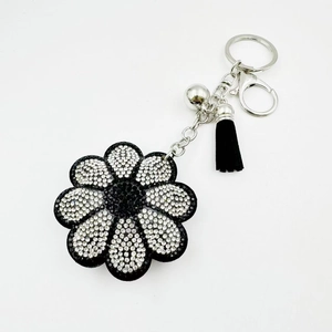 Porte-clés tournesol orné de strass noirs et blancs avec un pompon noir élégant