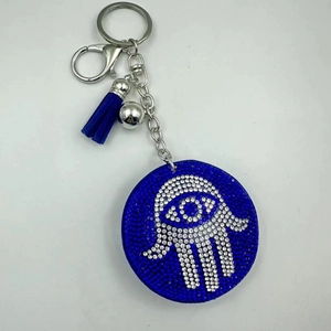 Close-up of a blue Hamsa Evil Eye keychain with sparkling rhinestones and a silk tassel