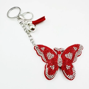 Porte-clés papillon en strass rouges avec base en velours et pendentif à pompon élégant