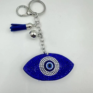 Detail of blue rhinestone evil eye keychain with matching fabric tassel and silver ring