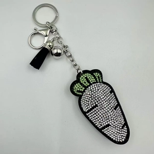 Détail d'un porte-clés carotte avec strass blancs brillants et pompon noir élégant