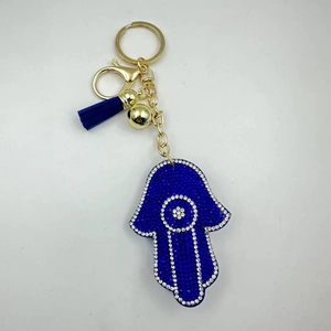 Macro detail of Hamsa Hand keychain with blue rhinestones and leather tassel