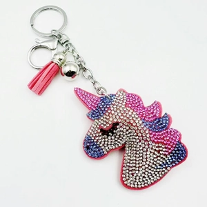 Detail of cartoon unicorn keychain with colorful rhinestones, leather tassel and bell
