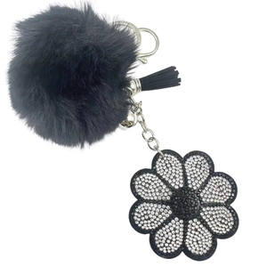 Plush black pompom keychain with rhinestone flower pendant and leather tassel for handbags