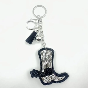 Detail of rhinestone western cowboy boot keychain with black leather tassel and silver bell