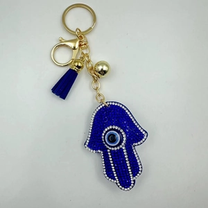 Detailed macro view of Hamsa Hand keychain with blue rhinestones and evil eye tassel charm
