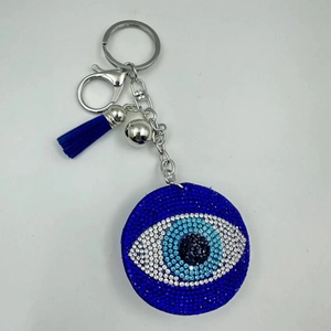 Detailed macro view of Evil Eye keychain featuring blue rhinestones and silk tassel