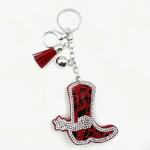 Detail of western cowboy boot keychain with leopard print, red tassel and rhinestones