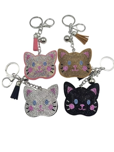 Detailed set of four rhinestone cat head keychains with tassels and bells in various colors