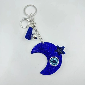 Detail of blue rhinestone moon and star keychain with Evil Eye charm and tassel