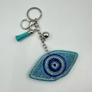Detail view of rhinestone evil eye keychain with blue tassels and metallic lobster clasp