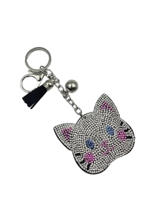 Detailed close-up of a rhinestone cat keychain with pink ears, blue bow, and black tassel