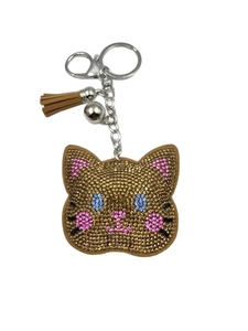 Close-up of sparkling rhinestone cat keychain with brown tassel and silver bell detail