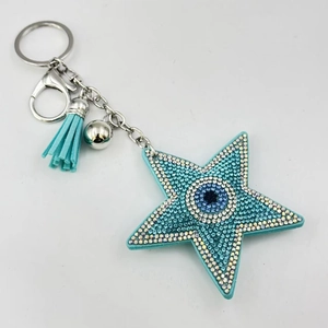 Détail du porte-clés étoile œil bleu avec strass brillants et pompon en cuir